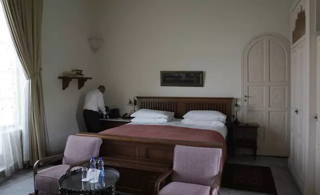 A worker readies a guest room at the American Colony Hotel in east Jerusalem, Sunday, Aug. 18, 2024. As Israel’s economy is suffering from the nearly 11-month war with Hamas, Jerusalem’s iconic American Colony hotel has had to lay off workers and are mulling pay cuts, said Jeremy Berkovitz, the official representative of the owners. (AP Photo/Mahmoud Illean)