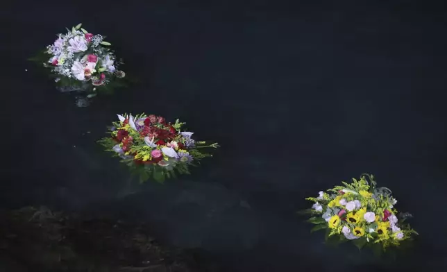 Flowers were sent out to sea as a tribute as Don Vincenzo the parish priest of Porticello in the municipality of Santa Flavia, celebrated mass for the victims of the Bayesian shipwreck in Porticello, Italy, Sunday, Aug. 25, 2024. (Alberto Lo Bianco/LaPresse via AP)