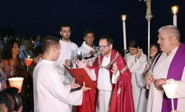 People gather as Don Vincenzo the parish priest of Porticello in the municipality of Santa Flavia, celebrates mass for the victims of the Bayesian shipwreck in Porticello, Italy, Sunday, Aug. 25, 2024. (Alberto Lo Bianco/LaPresse via AP)