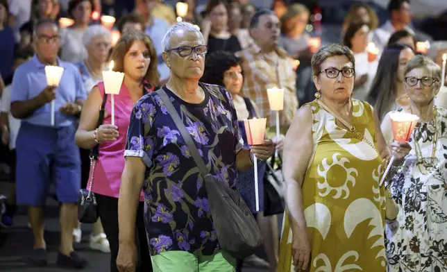 People gather as Don Vincenzo the parish priest of Porticello in the municipality of Santa Flavia, celebrates mass for the victims of the Bayesian shipwreck in Porticello, Italy, Sunday, Aug. 25, 2024. (Alberto Lo Bianco/LaPresse via AP)