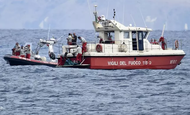 Italian Firefighters scuba divers bring ashore in a green bag the body of one of the victims of the UK flag vessel Bayesian, Wednesday, Aug. 21, 2024. The sail yacht was hit by a violent sudden storm and sunk early Monday, while at anchor off the Sicilian village of Porticello near Palermo, in southern Italy. (AP Photo/Salvatore Cavalli)