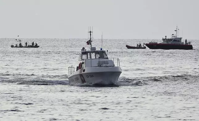 Emergency services at the scene of the search for a missing boat, in Porticello, southern Italy, Tuesday, Aug. 20, 2024. Rescue teams and divers returned to the site of a storm-sunken superyacht Tuesday to search for six people, including British tech magnate Mike Lynch, who are believed to be still trapped in the hull 50 meters (164-feet) underwater. (AP Photo/Salvatore Cavalli)