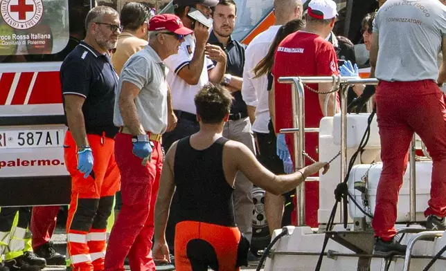 Rescuers bring ashore in a green bag the body of one of the victims of the UK flag vessel Bayesan that was hit by a violent sudden storm and sunk early Monday, Aug. 19, 2024, while at anchor off the Sicilian village of Porticello near Palermo, in southern Italy. (AP Photo/Lucio Ganci)