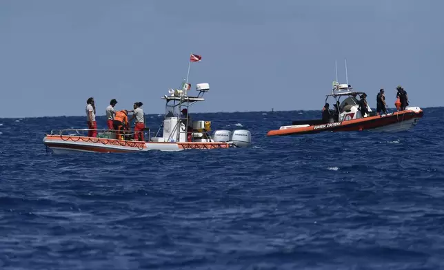 Scuba divers of the Italian Firefighters corp at the scene of the search for a missing boat, in Porticello, southern Italy, Wednesday, Aug. 21, 2024. Rescue teams and divers returned to the site of a storm-sunken superyacht Tuesday to search for six people, including British tech magnate Mike Lynch, who are believed to be still trapped in the hull 50 meters (164-feet) underwater. (AP Photo/Salvatore Cavalli)