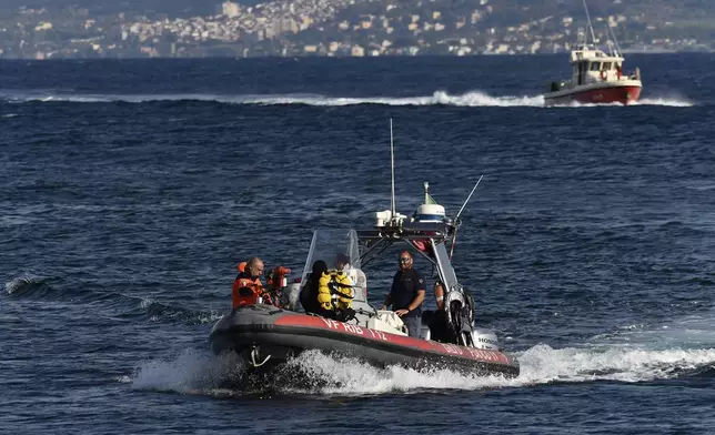 Emergency services at the scene of the search for a missing boat, in Porticello, southern Italy, Tuesday, Aug. 20, 2024. Rescue teams and divers returned to the site of a storm-sunken superyacht Tuesday to search for six people, including British tech magnate Mike Lynch, who are believed to be still trapped in the hull 50 meters (164-feet) underwater. (AP Photo/Salvatore Cavalli)