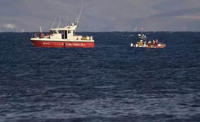 Emergency services at the scene of the search for a missing boat, in Porticello, southern Italy, Tuesday, Aug. 20, 2024. Rescue teams and divers returned to the site of a storm-sunken superyacht Tuesday to search for six people, including British tech magnate Mike Lynch, who are believed to be still trapped in the hull 50 meters (164-feet) underwater. (AP Photo/Salvatore Cavalli)