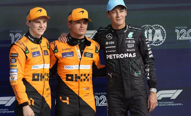 McLaren driver Lando Norris of Britain, centre, celebrates his pole position with second placed McLaren driver Oscar Piastri of Australia, left, and third Mercedes driver George Russell of Britain after qualifying session ahead of the Formula One Italian Grand Prix race at the Monza racetrack, in Monza, Italy, Saturday, Aug. 31, 2024. (AP Photo/Luca Bruno)