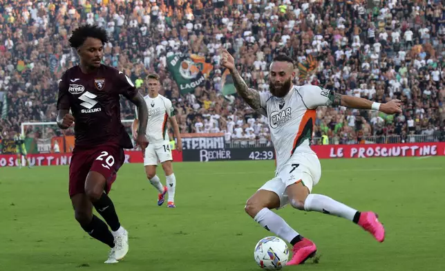 Venezia's Francesco Zampano, right, and Torino's Saul Coco in action during the Serie A soccer match between Venezia and Torino at the Pier Luigi Penzo Stadium in Venice, Italy, Friday Aug. 30, 2024. (Marco Alpozzi/LaPresse via AP)