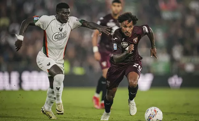 Venezia's Alfred Duncan, left, and Torino's Valentino Lazaro in action during the Serie A soccer match between Venezia and Torino at the Pier Luigi Penzo Stadium in Venice, Italy, Friday Aug. 30, 2024. (Marco Alpozzi/LaPresse via AP)