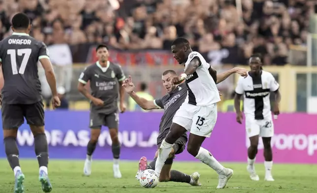 Parma's Ange Yoan Bonny, right, fights for the ball with Milan's Strahinja Pavlovic during the Italian Serie A soccer match between Parma and Milan at Parma's Ennio Tardini Stadium in Parma, Italy, Saturday Aug. 24, 2024. (Massimo Paolone/LaPresse via AP)