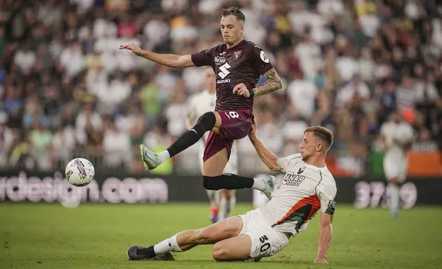 Torino's Ivan Ilic, left, and Venezia's Michael Svoboda in action during the Serie A soccer match between Venezia and Torino at the Pier Luigi Penzo Stadium in Venice, Italy, Friday Aug. 30, 2024. (Marco Alpozzi/LaPresse via AP)