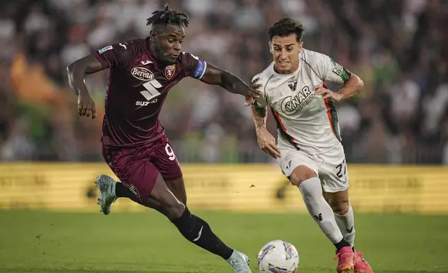 Torino's Duvan Zapata, left, and Venezia's Antonio Candela in action during the Serie A soccer match between Venezia and Torino at the Pier Luigi Penzo Stadium in Venice, Italy, Friday Aug. 30, 2024. (Marco Alpozzi/LaPresse via AP)