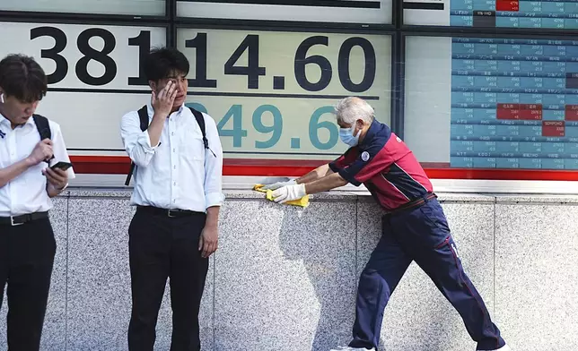 A custodian cleans an electronic stock board showing Japan's Nikkei index at a securities firm Monday, Aug. 26, 2024, in Tokyo. (AP Photo/Eugene Hoshiko)