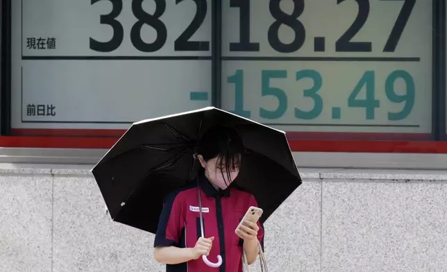 A person walks in front of an electronic stock board showing Japan's Nikkei index at a securities firm Thursday, Aug. 29, 2024, in Tokyo. (AP Photo/Eugene Hoshiko)