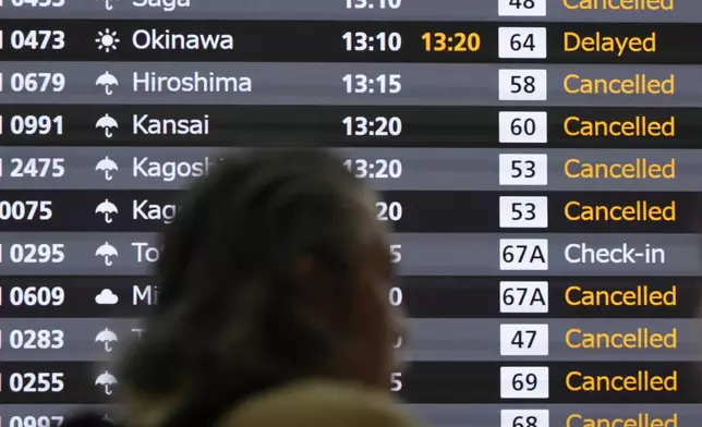 A notice board of departure flights is seen as many flights were canceled as a severe weather system is affecting Japan, at Haneda airport Friday, Aug. 30, 2024, in Tokyo. (AP Photo/Eugene Hoshiko)