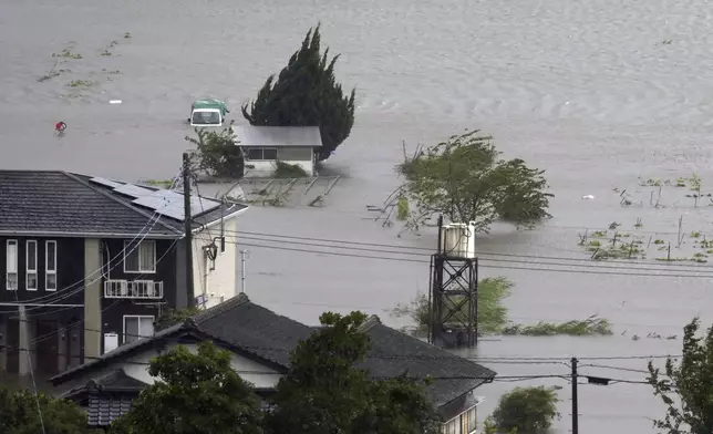 Farmland along a river is flooded by heavy rains caused by a typhoon in Yufu, Oita prefecture, western Japan, Thursday, Aug. 29, 2024. (Kyodo News via AP)