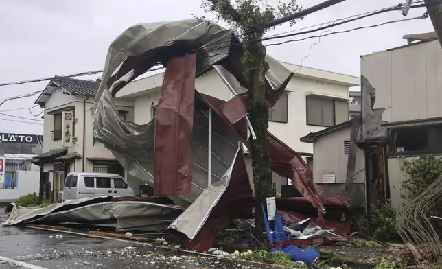 A metal object blown away by strong winds of a typhoon is caught on a power line in Miyazaki, western Japan, Thursday, Aug. 29, 2024. (Kyodo News via AP)