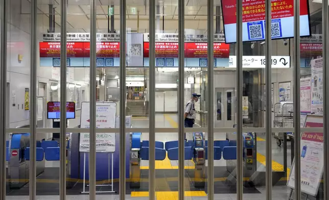 The gate for Tokaido and Sanyo Shinkansen is closed as all trains toward to Nagoya or westward were canceled due to heavy rainfall from Typhoon Shanshan at Tokyo Station, Friday, Aug. 30, 2024, in Tokyo. (AP Photo/Eugene Hoshiko)