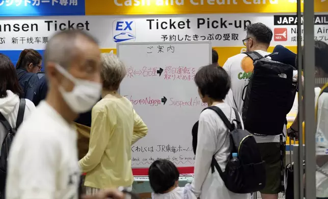 People queue to refund or change their tickets on trains of Tokaido and Sanyo Shinkansen toward to Nagoya or westward canceled due to heavy rainfall caused by Typhoon Shanshan at Tokyo Station Friday, Aug. 30, 2024, in Tokyo. (AP Photo/Eugene Hoshiko)