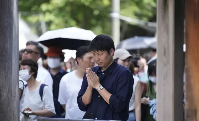 A man prays near the main hall at Yasukuni Shrine, which honors Japan's war dead, in Tokyo, Japan, Thursday, Aug. 15, 2024, as the country marks the 79th anniversary of its defeat in the World War II. (AP Photo/Hiro Komae)