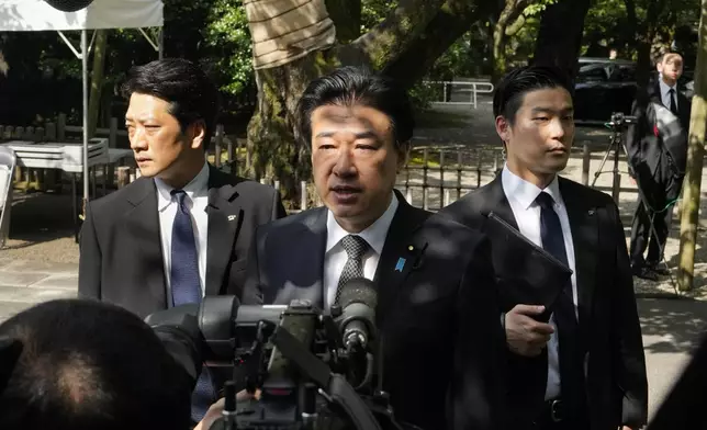 Japanese Defense Minister Minoru Kihara, center, speaks to media members after offering prayer for the war dead at Yasukuni Shrine in Tokyo, Japan, Thursday, Aug. 15, 2024, as the country marks the 79th anniversary of its defeat in the World War II. (AP Photo/Hiro Komae)