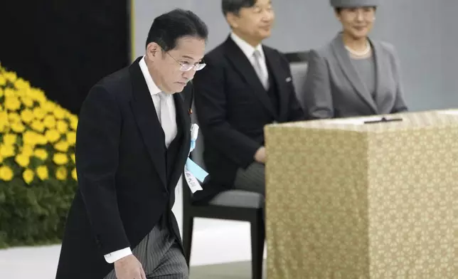 Japan's Prime Minister Fumio Kishida, left, walks past Emperor Naruhito and Empress Masako, after his speech during a memorial service for the war dead at the Nippon Budokan hall in Tokyo, as the country marks the 79th anniversary of its defeat in the World War II, Thursday, Aug. 15, 2024. (Kyodo News via AP)