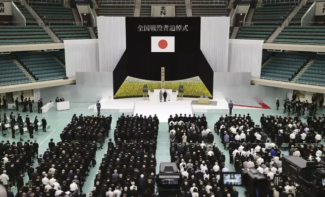 Japan's Emperor Naruhito, rear right, and Empress Masako, rear left, observe a moment of silence during a memorial service for the war dead at the Nippon Budokan hall in Tokyo, as the country marks the 79th anniversary of its defeat in the World War II, Thursday, Aug. 15, 2024. (Kyodo News via AP)