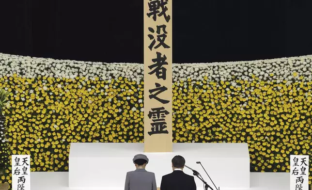 Japan's Emperor Naruhito, right, and Empress Masako, left, observe a moment of silence during a memorial service for the war dead at the Nippon Budokan hall in Tokyo, as the country marks the 79th anniversary of its defeat in the World War II, Thursday, Aug. 15, 2024. (Kyodo News via AP)