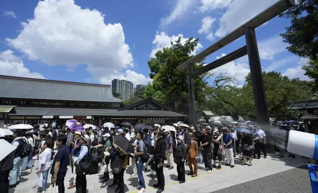 People wait in queue before reaching to the main hall to pray at Yasukuni Shrine, which honors Japan's war dead, in Tokyo, Japan, Thursday, Aug. 15, 2024, as the country marks the 79th anniversary of its defeat in the World War II. (AP Photo/Hiro Komae)