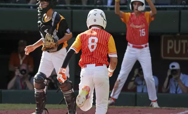 Boerne, Texas' Gray Collins (8) and Julian Hurst (15) score past Lake Mary, Fla.'s Landon Bono, left, on a double by Doc Mogford during the third inning of the United States Championship baseball game at the Little League World Series tournament in South Williamsport, Pa., Saturday, Aug. 24, 2024. (AP Photo/Gene J. Puskar)