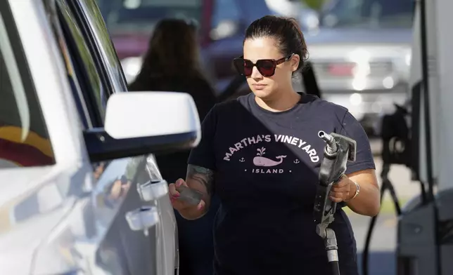 A woman fuels her car at the gateway to Cape Cod in Sagamore, Mass., Friday, Aug. 30, 2024. (AP Photo/Michael Dwyer)