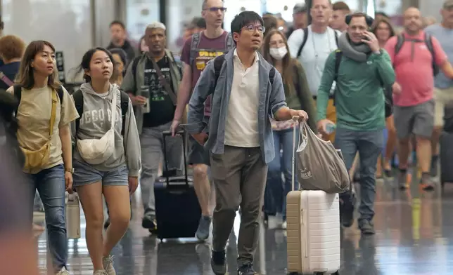 FILE - Travelers pass through Salt Lake City International Airport on July 3, 2024, in Salt Lake City. (AP Photo/Rick Bowmer, File)