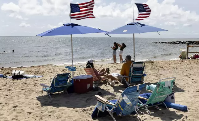 People fly the American flag on their beach umbrellas, Friday, Aug. 30, 2024, in Dennis Port, Mass. (AP Photo/Michael Dwyer)