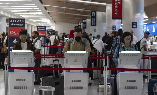 Travelers use kiosks to check in for flights in the Delta Airlines ticketing area at the Los Angeles International Airport in Los Angeles, Friday, Aug. 30, 2024. (AP Photo/Jae C. Hong)