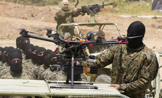 A Hezbollah fighter stands next to an armed drone during a training exercise in Aaramta village in the Jezzine District, southern Lebanon, on May 21, 2023. . (AP Photo/Hassan Ammar)