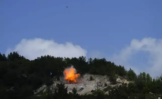 An explosion from a drone strike causes a ball of fire as fighters from the Lebanese militant group Hezbollah carry out a training exercise in Aaramta village in the Jezzine District, southern Lebanon, on May 21, 2023. I (AP Photo/Hassan Ammar, File)