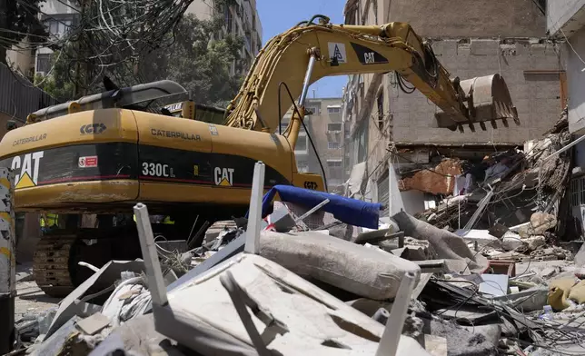 A backhoe removes rubbles from a building that was destroyed by an Israeli airstrike on Tuesday evening in a southern suburb of Beirut, Lebanon, Wednesday, July 31, 2024. (AP Photo/Hussein Malla)