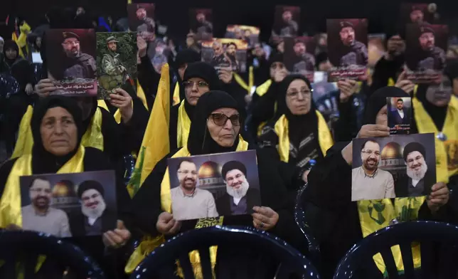 Hezbollah supporters hold portraits that show Hezbollah leader Sayyid Hassan Nasrallah and one of his commander Fouad Shukur, who was killed by an Israeli airstrike last week, during a ceremony to commemorate his death in Beirut, Lebanon, Tuesday, Aug. 6, 2024. (AP Photo/Mustafa Jamalddine)