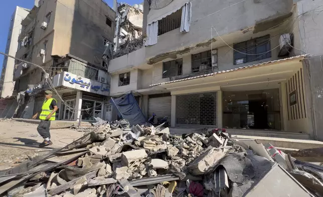 A municipality worker passes by debris of damaged buildings that were hit by an Israeli airstrike on Tuesday evening in the southern suburbs of Beirut, Lebanon, Wednesday, July 31, 2024. (AP Photo/Hussein Malla)