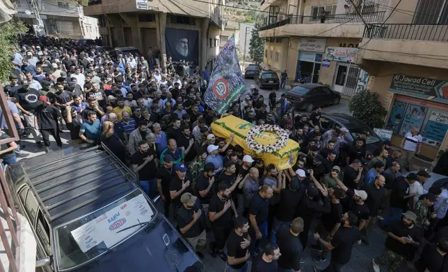 Mourners carry the coffin of Ali Ahmad Mousawi, who was killed early Wednesday by an Israeli strike, during his funeral procession in Nabi Sheet village, in Lebanon's eastern Bekaa Valley, Wednesday, Aug. 21, 2024. (AP Photo/Bilal Hussein)