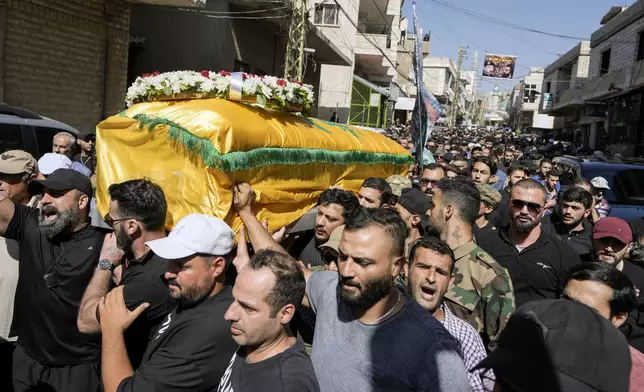 Mourners chant slogans as they carry the coffin of Ali Ahmad Mousawi, who was killed early Wednesday by an Israeli strike, during his funeral procession in Nabi Sheet village, in Lebanon's eastern Bekaa Valley, Wednesday, Aug. 21, 2024. (AP Photo/Bilal Hussein)