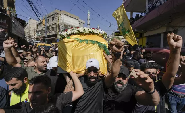 Mourners chant slogans as they carry the coffin of Ali Ahmad Mousawi, who was killed early Wednesday by an Israeli strike, during his funeral procession in Nabi Sheet village, in Lebanon's eastern Bekaa Valley, Wednesday, Aug. 21, 2024. (AP Photo/Bilal Hussein)