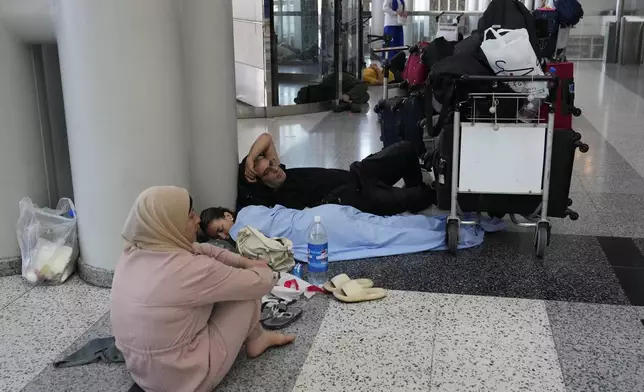 Passengers whose flights were cancelled, wait at the departure terminal ground of Rafik Hariri International Airport, in Beirut, Lebanon, Monday, Monday, Aug. 5, 2024. Turkey and Japan became the latest countries to urge their citizens to leave Lebanon amid rising tensions with Israel following last week's airstrike in Beirut that killed a top Hezbollah military commander. Fears of an escalation in the simmering conflict between Hezbollah and Israel have prompted some airlines to cancel flights to Lebanon. (AP Photo/Hussein Malla)