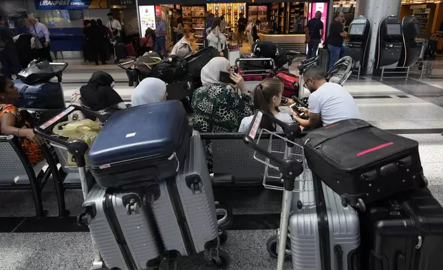 Passengers whose flights were cancelled, wait at the departure terminal of Rafik Hariri International Airport, in Beirut, Lebanon, Monday, Monday, Aug. 5, 2024. Turkey and Japan became the latest countries to urge their citizens to leave Lebanon amid rising tensions with Israel following last week's airstrike in Beirut that killed a top Hezbollah military commander. Fears of an escalation in the simmering conflict between Hezbollah and Israel have prompted some airlines to cancel flights to Lebanon. (AP Photo/Hussein Malla)