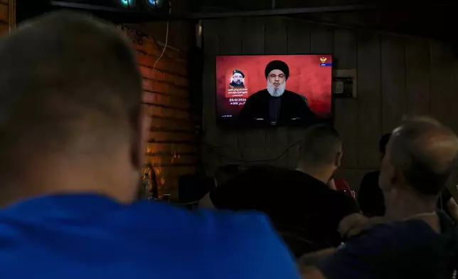 People listen to a speech by Hezbollah leader Sayyed Hassan Nasrallah broadcasted on Hezbollah's al-Manar television channel, at a coffee shop in a southern suburb of Beirut, Lebanon, Sunday, Aug. 25, 2024, hours after Israel and Hezbollah traded heavy fire. (AP Photo/Bilal Hussein)