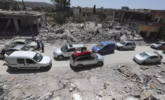 FILE - People inspect their destroyed houses that were hit by an Israeli airstrike, in Aita al-Shaab village, south Lebanon, June 29, 2024. (AP Photo/Mohammed Zaatari, File)