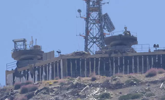 FILE - A damaged Israeli military position targeted by Hezbollah fighters is seen on the top of Mount Hermon in the Israeli-controlled Golan Heights, where the borders among Israel, Syria and Lebanon meet are seen from Chebaa, a Lebanese town near the border with Israel, south Lebanon, June 26, 2024. (AP Photo/Hussein Malla, File)