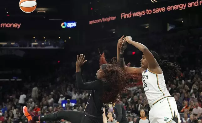 Phoenix Mercury guard Kahleah Copper, left, tips away a pass intended for New York Liberty forward Jonquel Jones (35) during the first half of a WNBA basketball game Monday, Aug. 26, 2024, in Phoenix. (AP Photo/Ross D. Franklin)