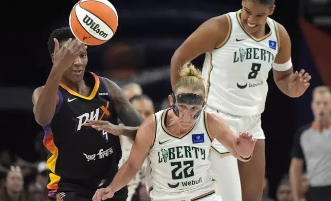 Phoenix Mercury forward Natasha Mack, left, collides with New York Liberty guard Courtney Vandersloot (22) as Liberty forward Nyara Sabally (8) looks on during the first half of a WNBA basketball game Monday, Aug. 26, 2024, in Phoenix. (AP Photo/Ross D. Franklin)