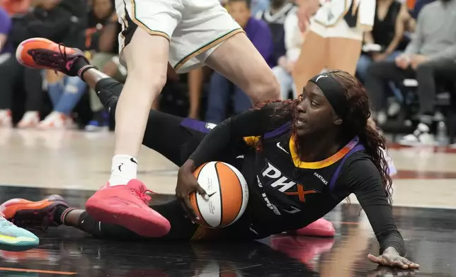 Phoenix Mercury guard Kahleah Copper, bottom, slides across the court during the second half of a WNBA basketball game against the New York Liberty, Monday, Aug. 26, 2024, in Phoenix. (AP Photo/Ross D. Franklin)